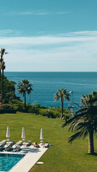 Luxurious poolside with lush greenery and scenic Mediterranean sea view in Antalya, Türkiye.