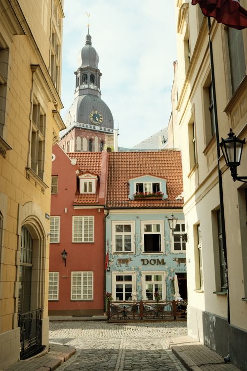 Free Idyllic narrow street view in Riga's Old Town featuring iconic architecture and Riga Cathedral. Stock Photo