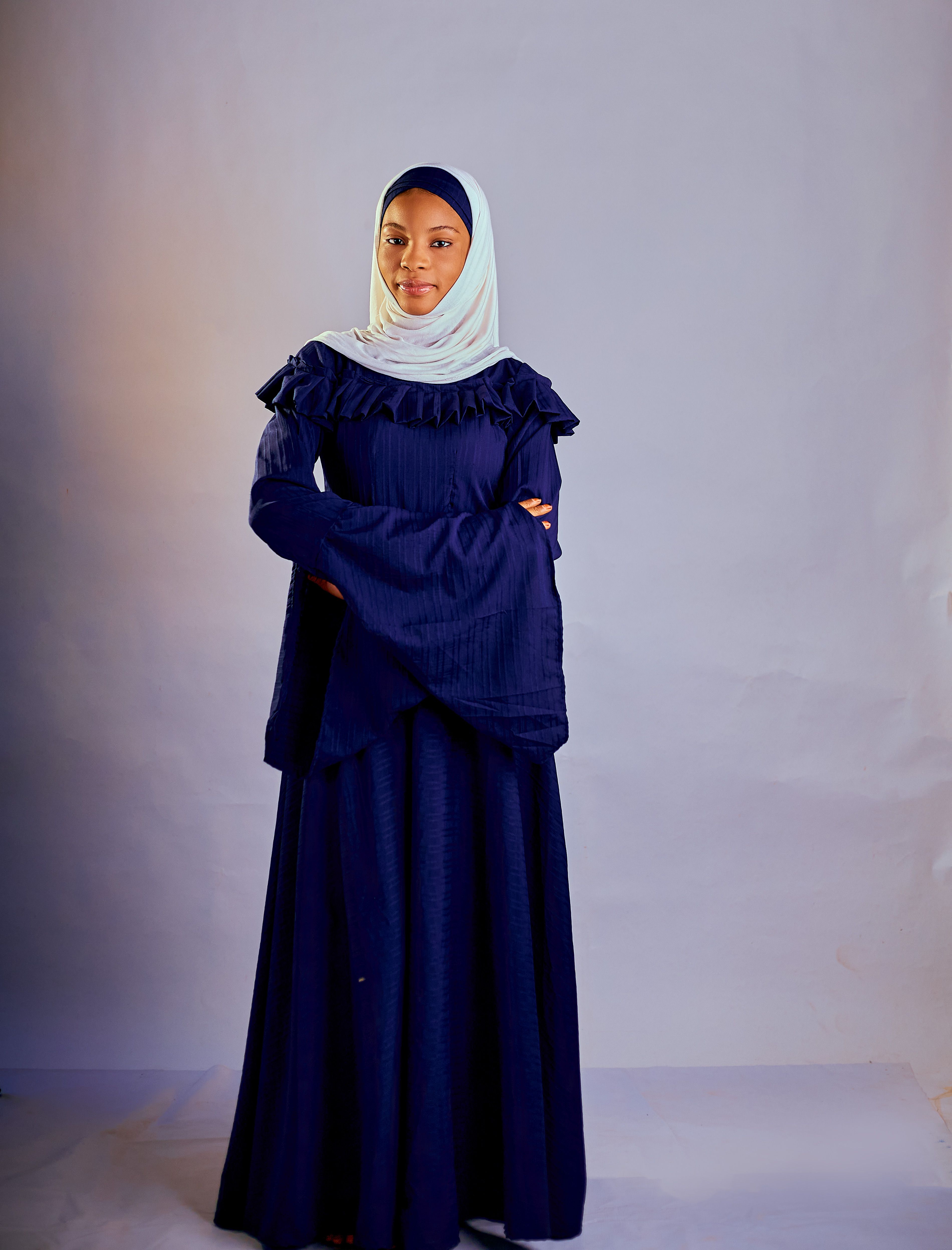 Elegant portrait of a woman wearing a blue traditional dress and headscarf.