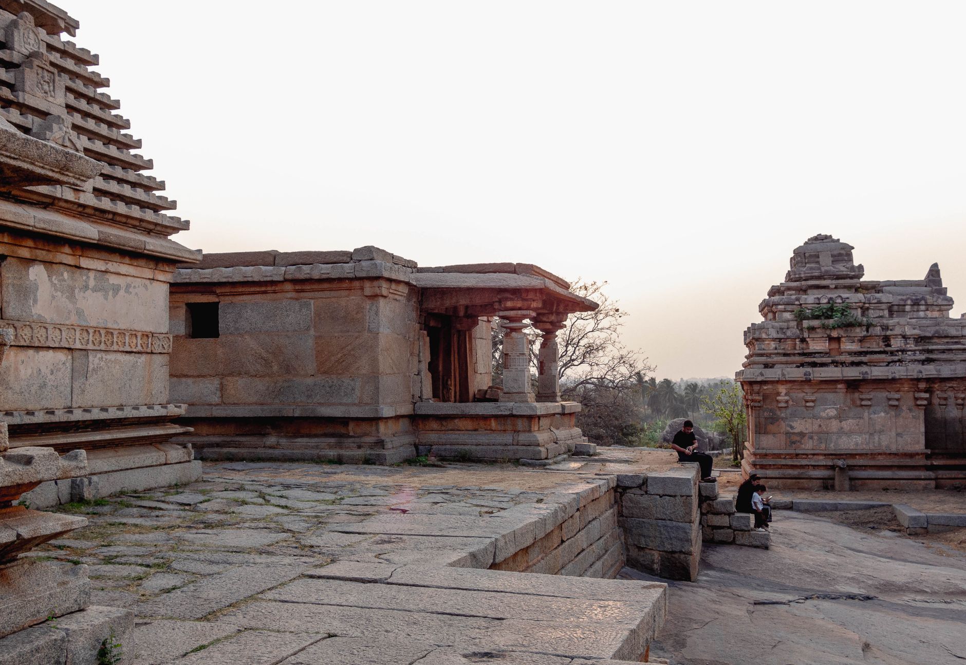 Explore the historical architecture of Hampi's ancient temples in Karnataka, India at sunset.