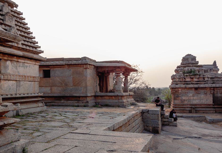 Explore the historical architecture of Hampi's ancient temples in Karnataka, India at sunset.