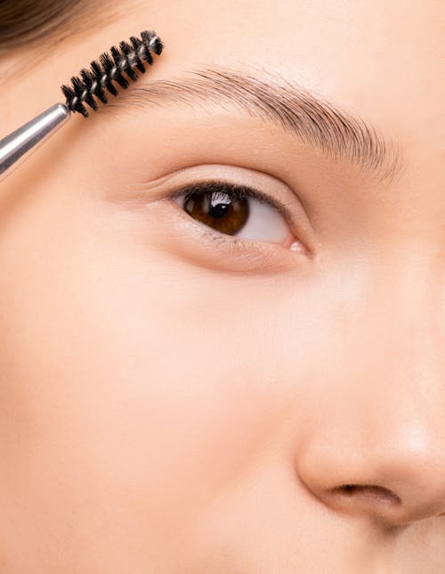 Free Woman Applying Mascara Stock Photo