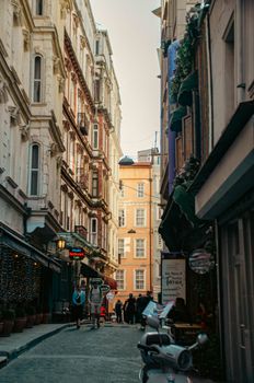 Charming alley in a European city with vintage architecture, bustling with pedestrians and cafes.