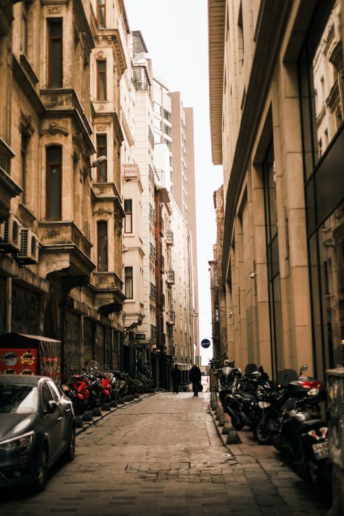 Free Bustling urban alleyway between historic buildings showcasing city life. Stock Photo