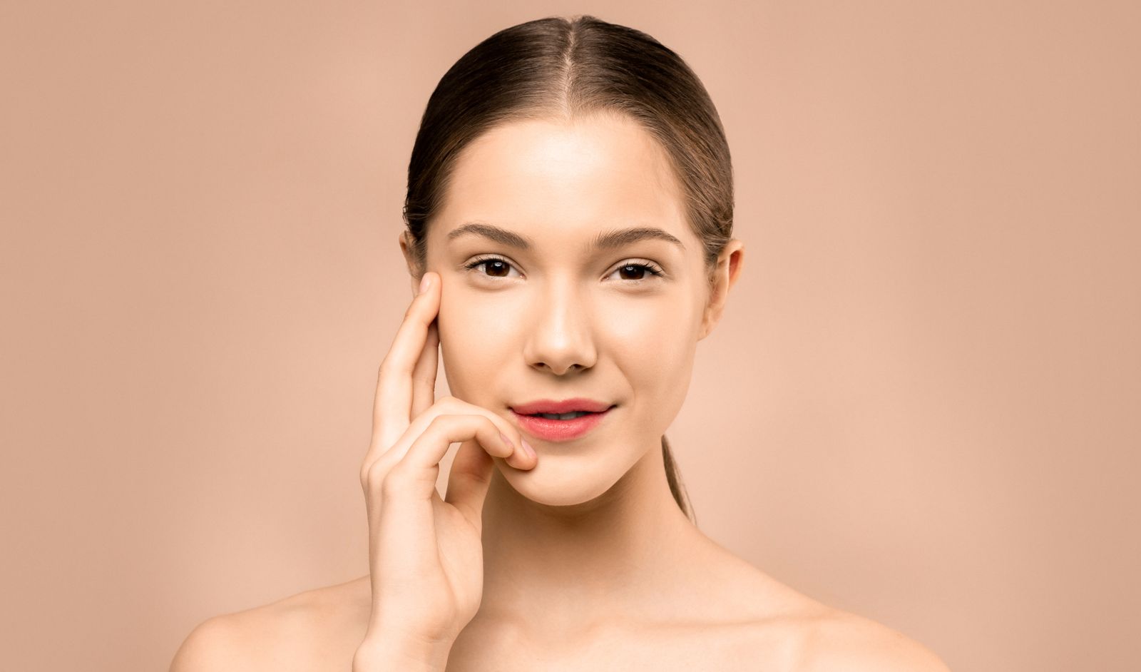 Woman with clear, glowing skin and a gentle smile after a face yoga and skincare routine