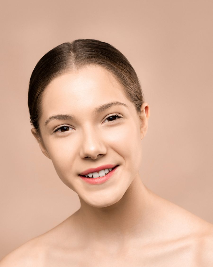 Smiling woman with smooth, clear, light-reflecting skin, representing glass skin treatment at Bailor Clinic in Sinsa, Gangnam