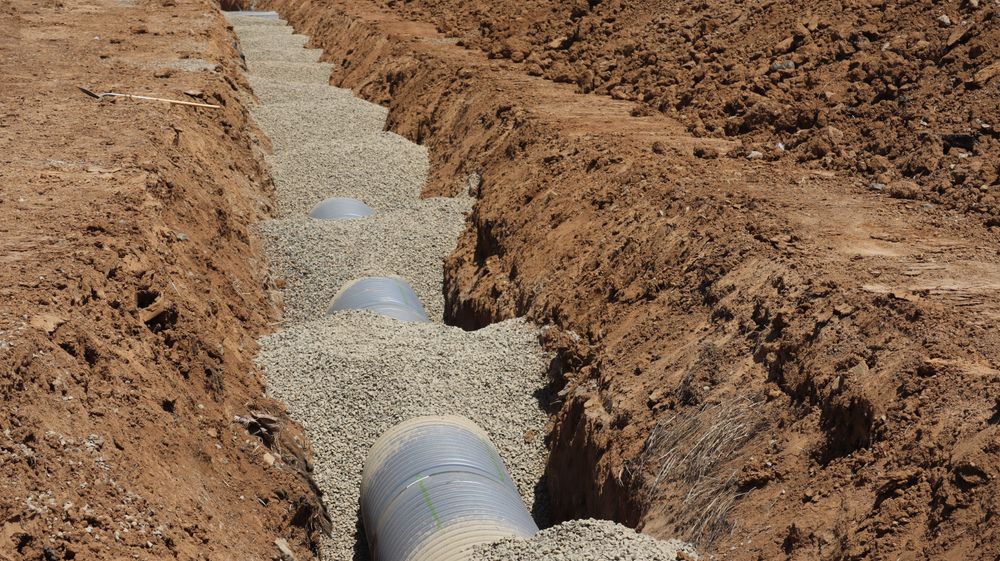 New sewer pipe bedded in gravel in an open trench