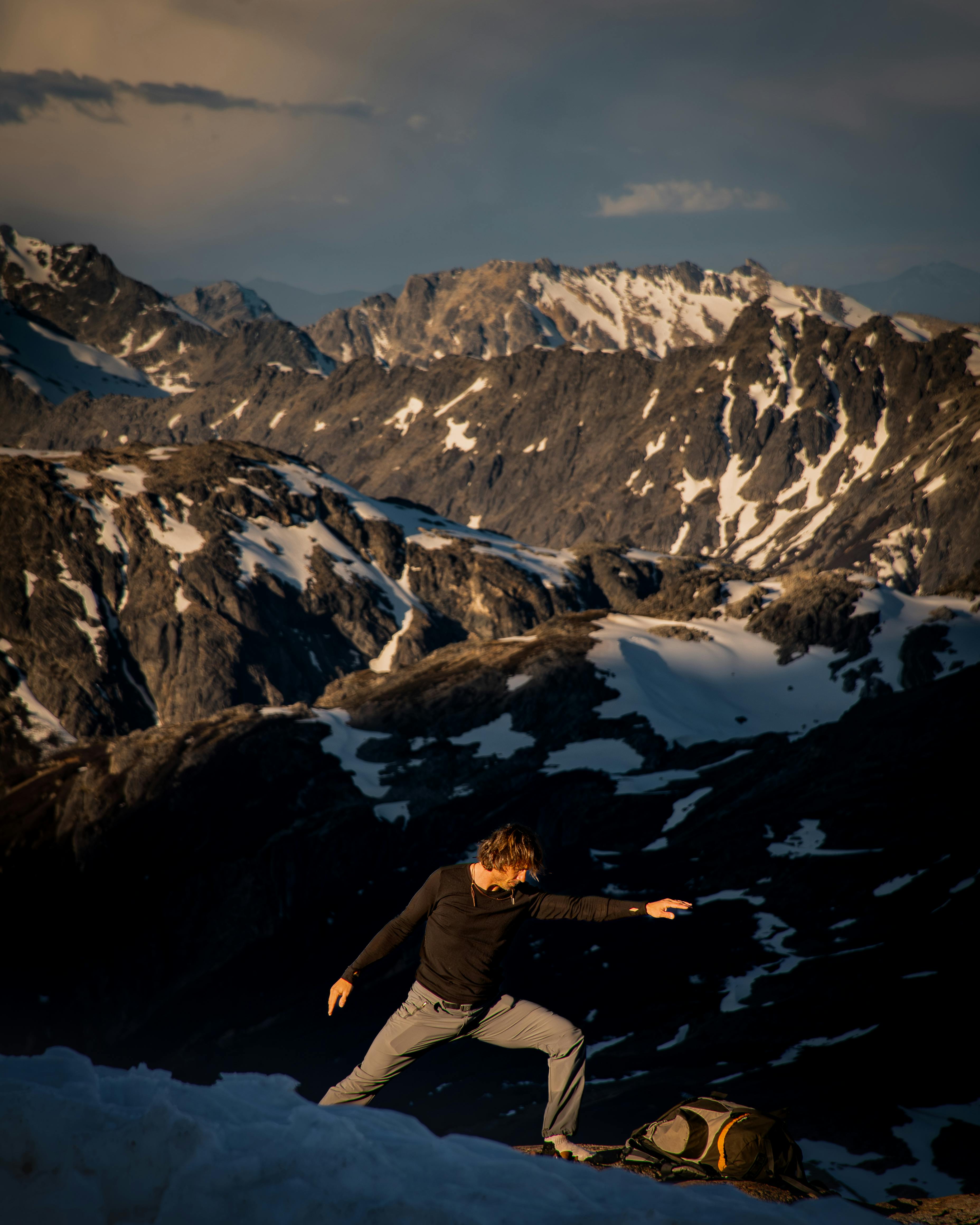 Person practicing yoga on a snowy mountain in Bariloche at sunset.