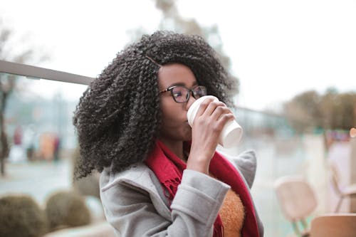 Free Selective Focus Photo of Woman in Gray Coat Drinking Coffee Stock Photo