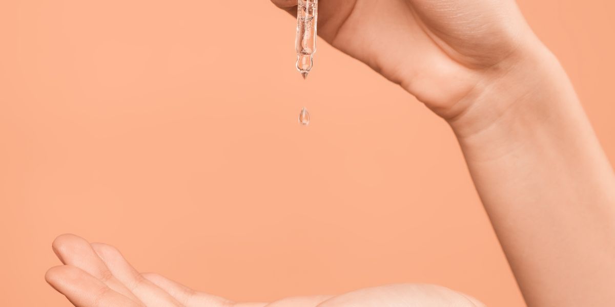 Woman applying serum to damp skin