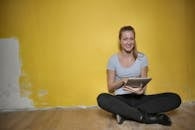 Woman Sitting On Wooden Floor Using Tablet