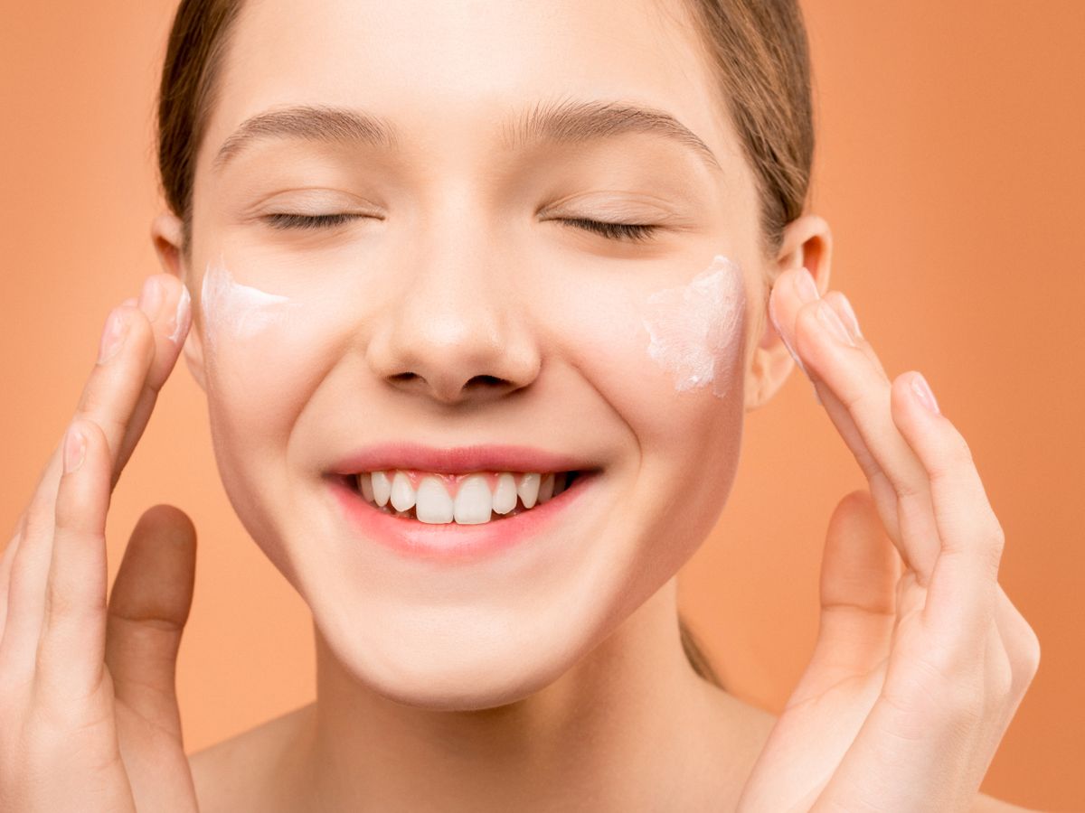 Woman applying moisturizer to her face