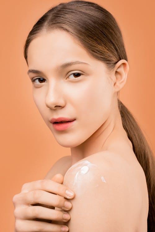 Free Woman Applying Lotion on Her Skin Stock Photo