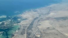 Aerial view of a coastal desert landscape with roads and settlements along the shoreline.
