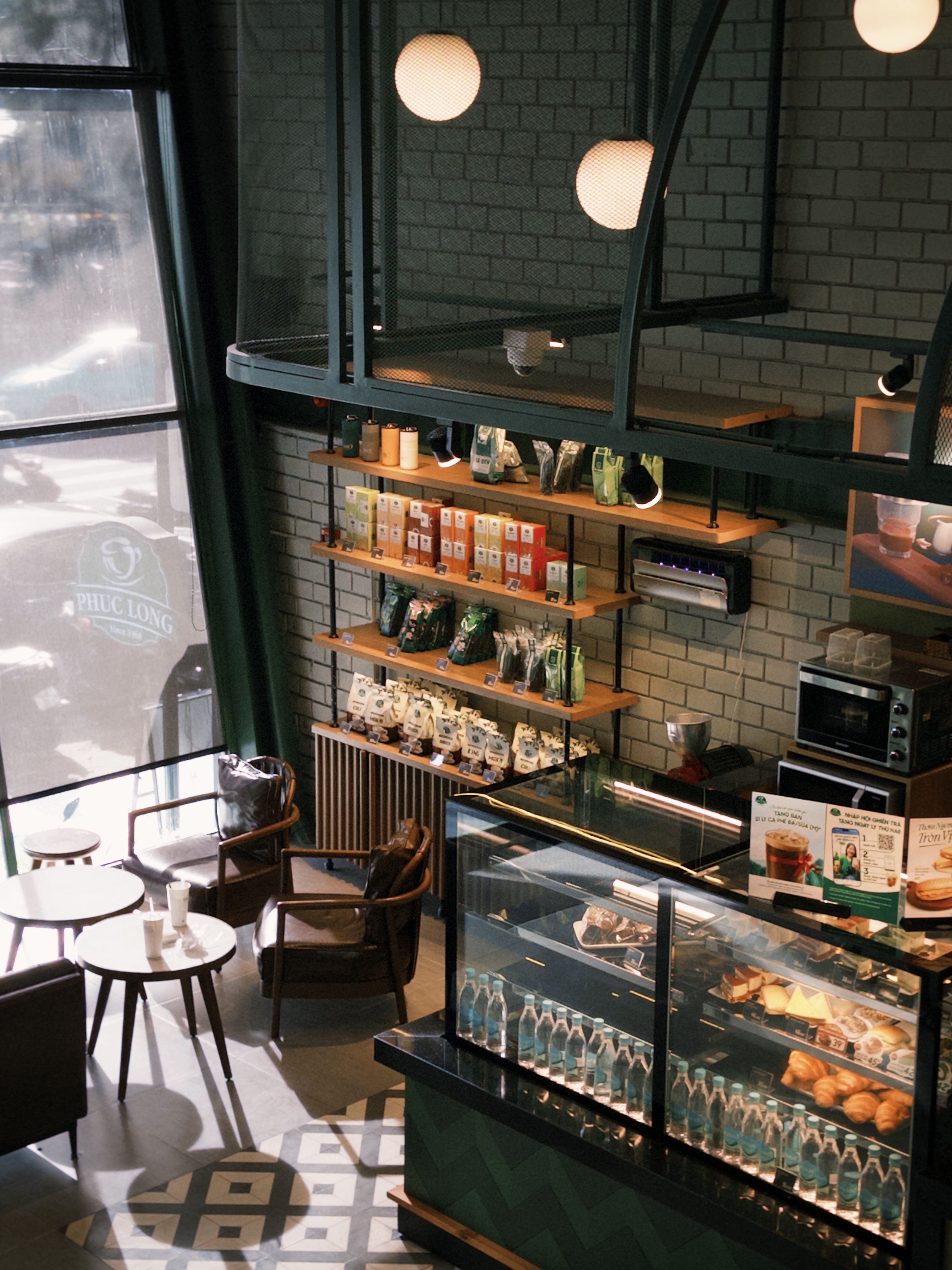 Warm and inviting cafe interior with seating and a display of pastries. Perfect for coffee lovers.