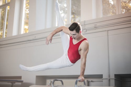 Free Photo of Male Gymnast Practicing in Gym Stock Photo