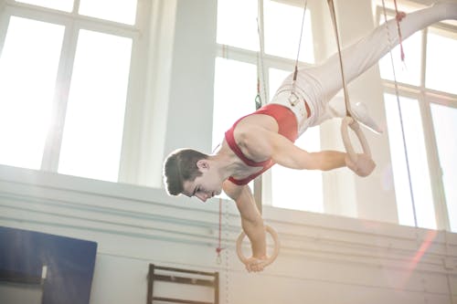 男體操運動員在體操環上練習的照片