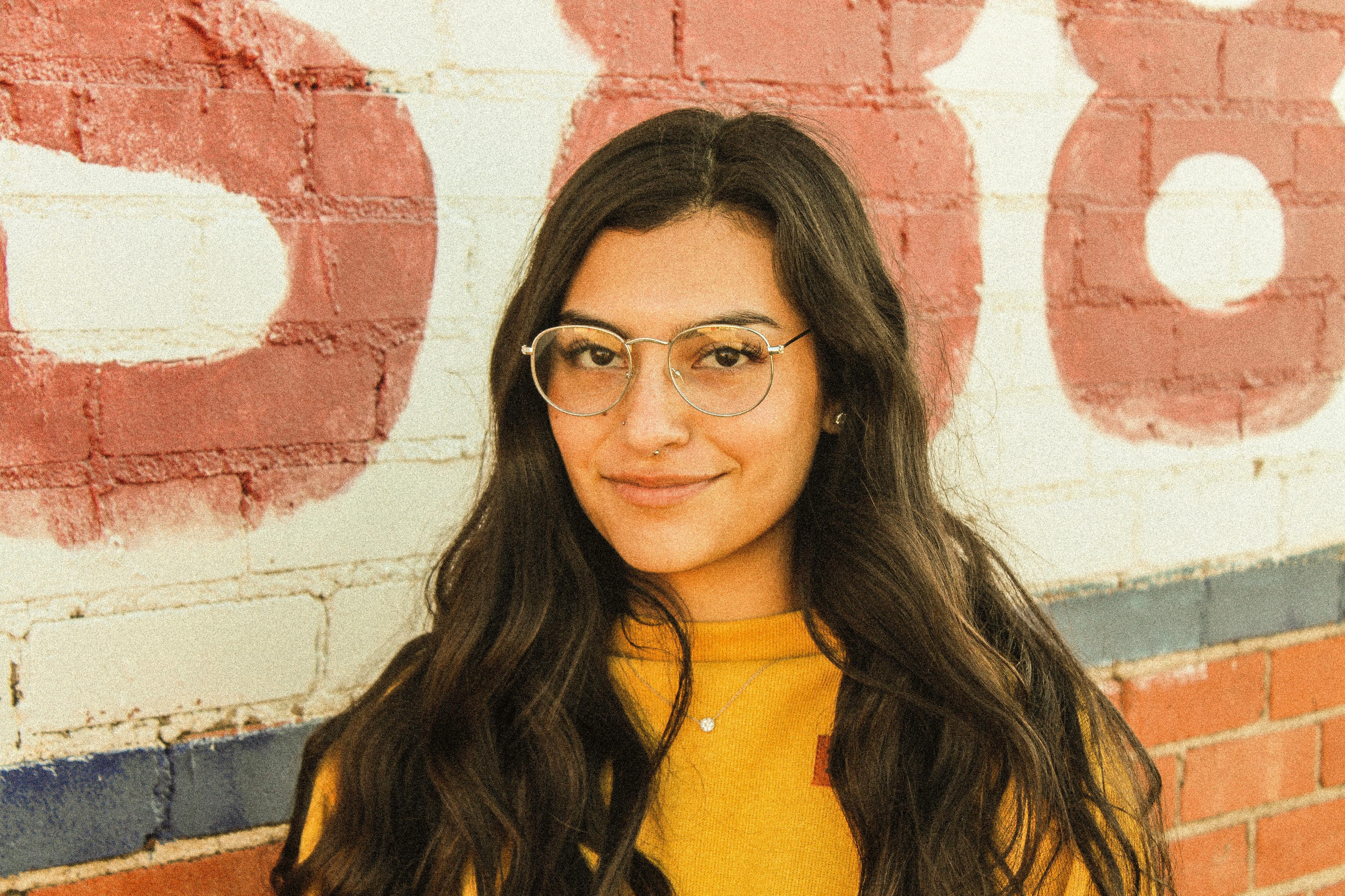 户外彩绘砖墙上有一幅戴着眼镜的微笑女人的肖像