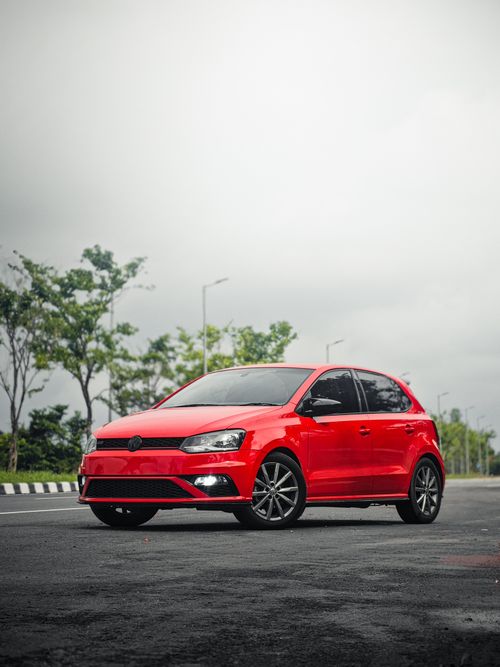 Free A striking red hatchback car parked outdoors in Kochi, Kerala under a cloudy sky. Stock Photo