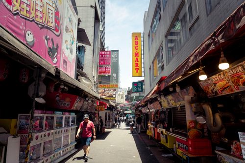 Free Street view of a lively market in Taipei, Taiwan with vibrant signs and diverse eateries. Stock Photo