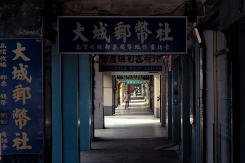 Free Urban alley in Taipei, Taiwan with traditional Chinese signage and a distant figure, creating a moody atmosphere. Stock Photo