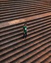 Man in Green Shirt Standing On Brown Concrete Stairs