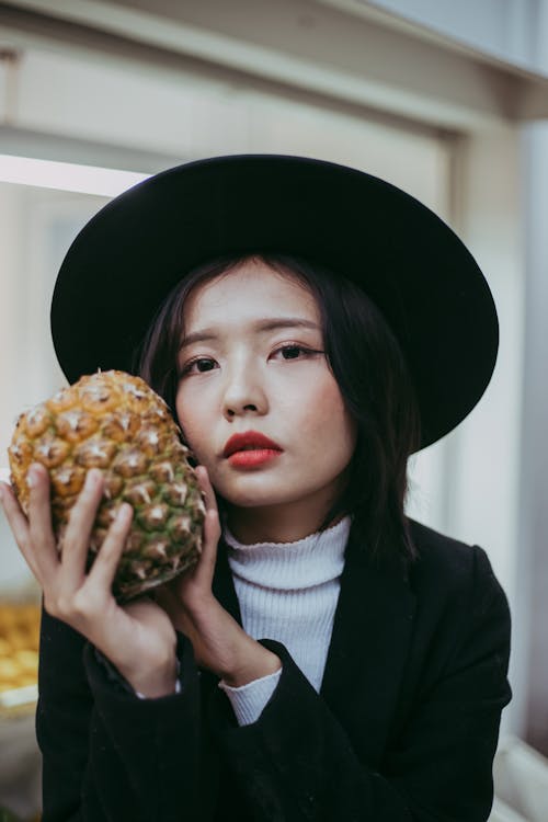 Woman in Black Hat Holding Pineapple