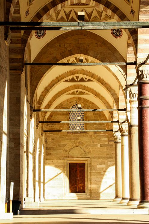 Free A beautifully lit mosque corridor with ornate arches in Istanbul, showcasing intricate design. Stock Photo