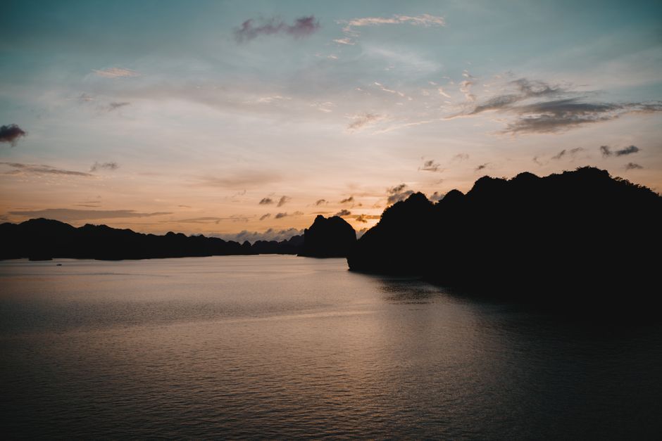 Tranquil sunset over Halong Bay, Vietnam with silhouette of limestone islands.