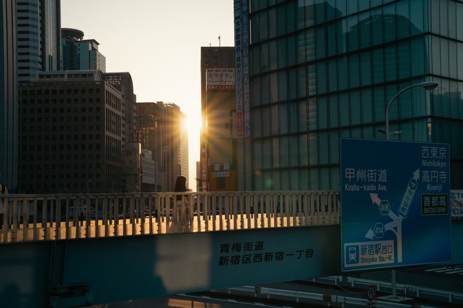 A captivating urban sunset view in Tokyo showcasing city skyscrapers and a pedestrian bridge.