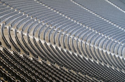 An empty stadium with cascading rows of seats, perfect for events and sports.