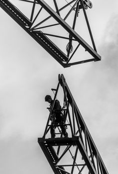 Black and white photo of a construction worker on a crane structure.