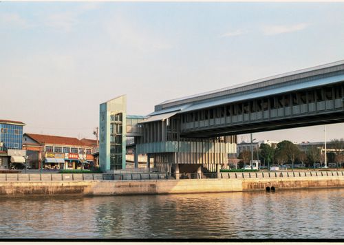 Free A modern bridge and building along a waterfront during daytime. Stock Photo