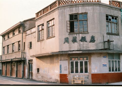 Free Aged concrete building on urban street corner featuring old signage. Stock Photo