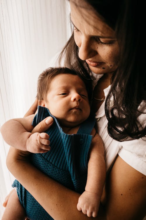 Free Close-Up Photo of Mother Carrying Her Baby Stock Photo