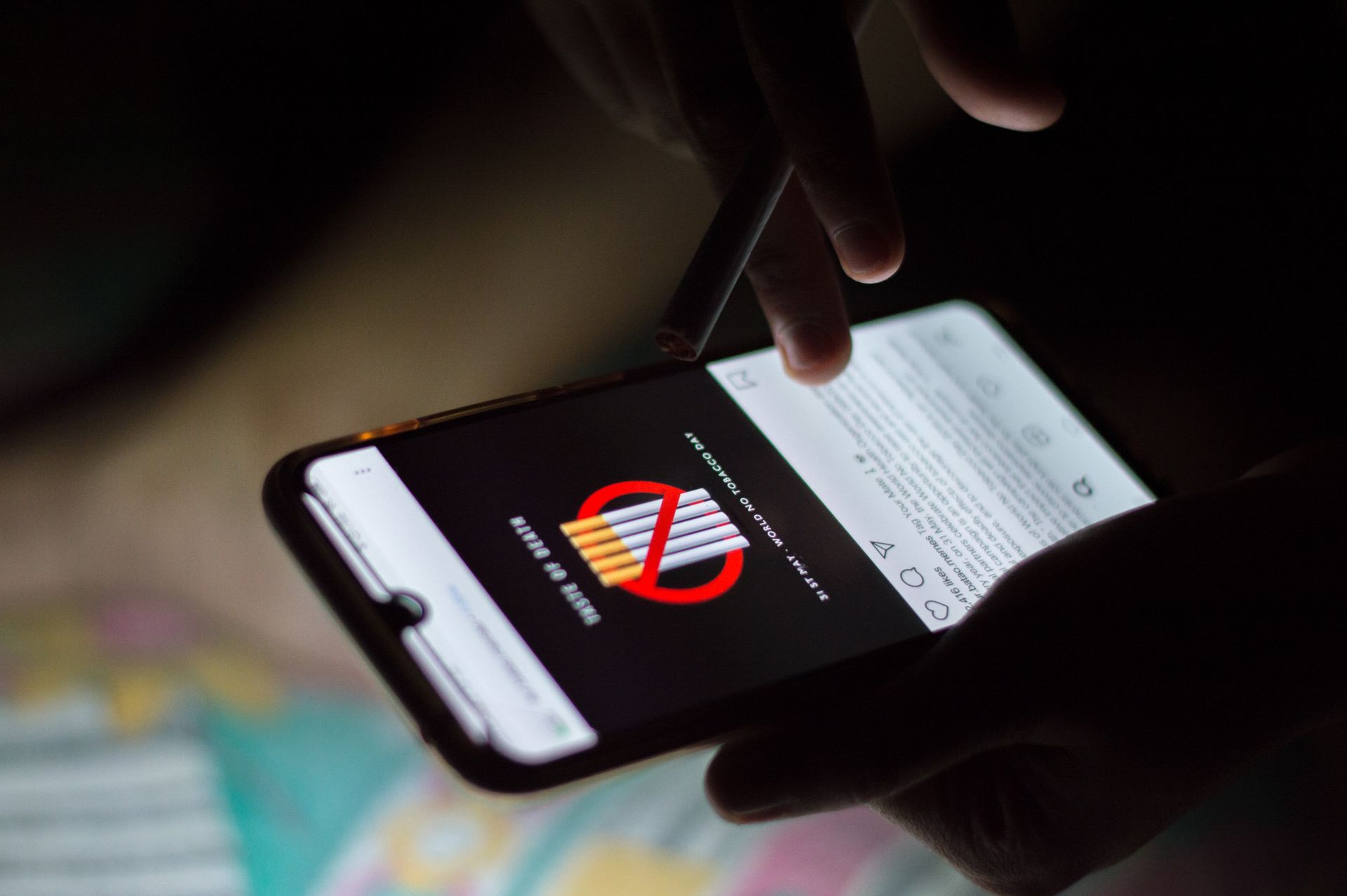 Selective Focus Close-up Photo of Person Using a Smartphone While Holding a Cigarette