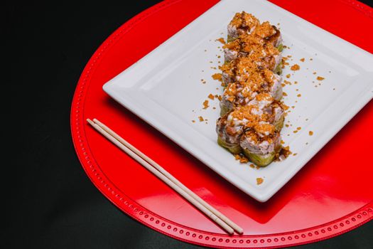 白色盘子里，顶视图下的美味寿司卷配着酥脆浇头，堪称完美的食物摄影