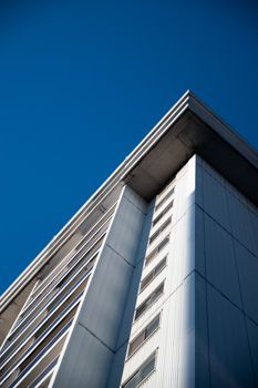 Dynamic low-angle architectural shot of a modern building under a clear blue sky in Montreal.