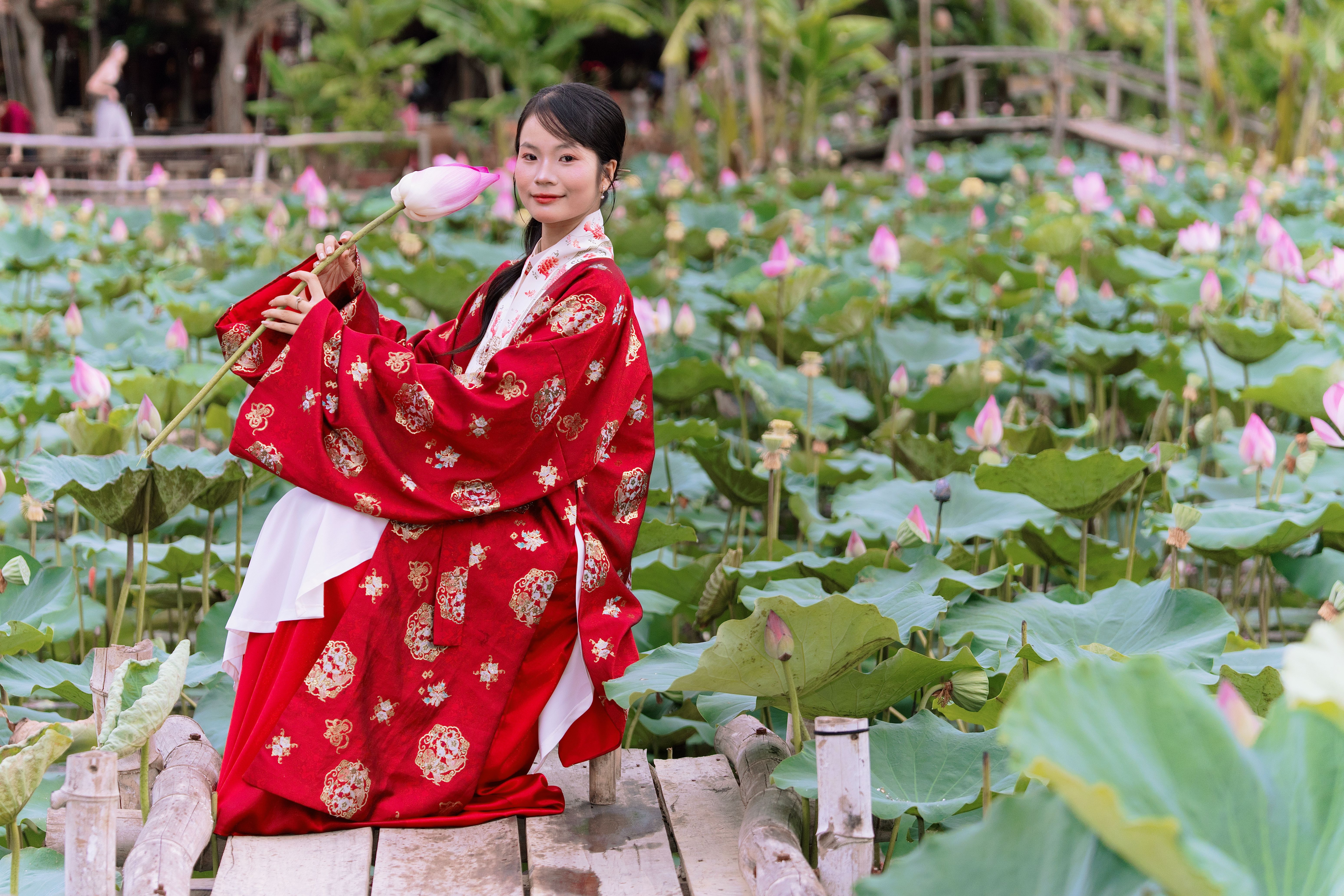 Woman in Traditional Dress Amidst Lotus Pond · Free Stock Photo