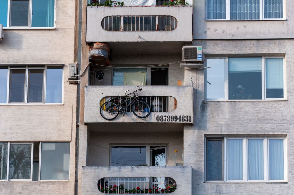 5 Essential Corner Rack for Balcony Ideas to Maximize Small Space Storage Person using a corner rack for balcony storage and organization
