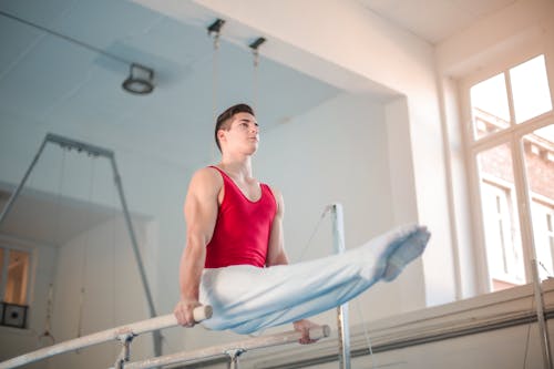 Free Photo of Male Gymnast Practicing in Gym Stock Photo