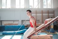 Young sportsman sitting on gymnastic equipment