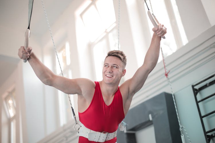 Strong Man In Harness Holding Gymnastic Rings