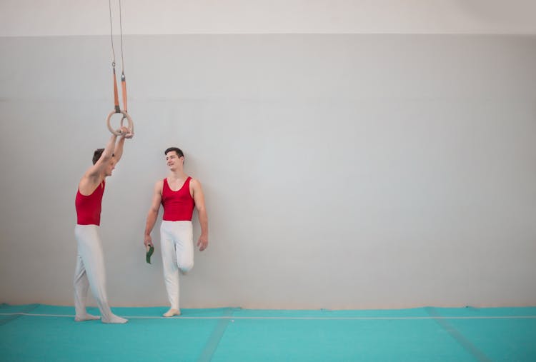 Young Professional Sportsmen Talking In Gymnastics Hall