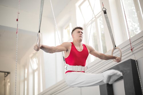 Foto De Gimnasta Masculino Practicando En Anillos De Gimnasia