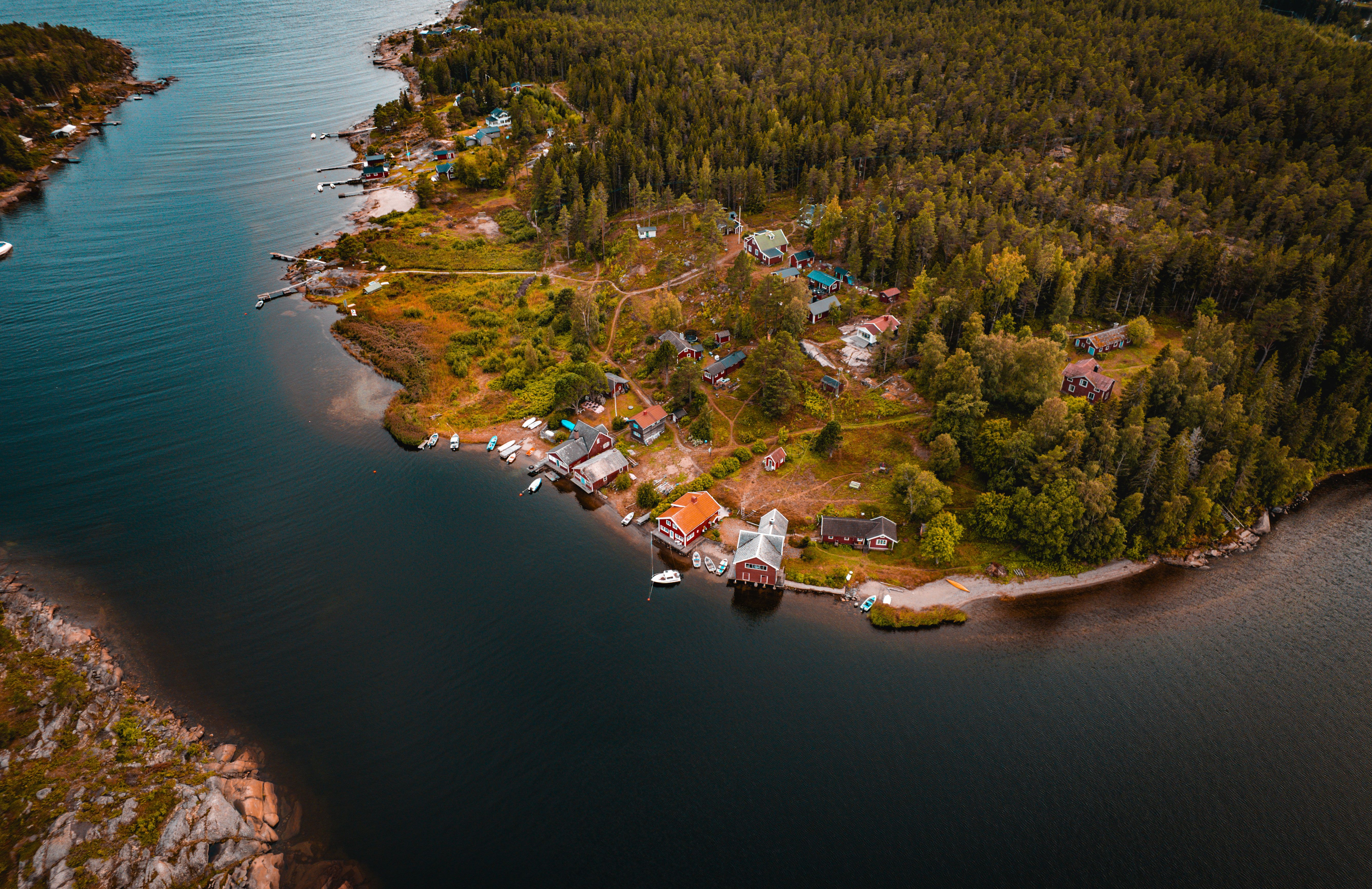 Aerial view of a coastal island village surrounded by forests and calm water