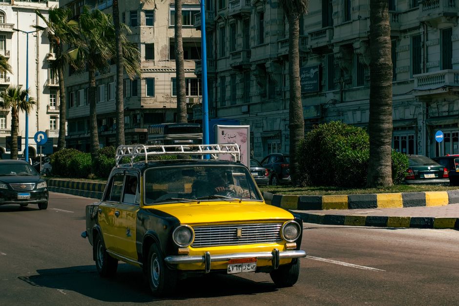 Interior of a modern car rental office in Cairo, Egypt, with a friendly agent assisting a customer.