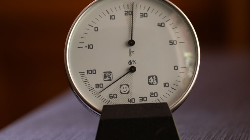 digital hygrometer showing room humidity on a living room shelf