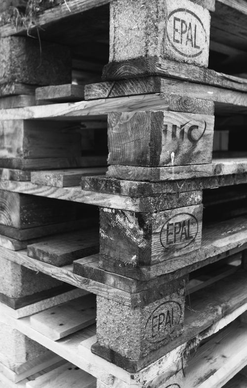 Free Close-up view of neatly stacked wooden pallets, showcasing texture in monochrome. Stock Photo