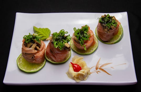 Elegant salmon sushi rolls garnished with greens on a lime slice in a fine dining setting.